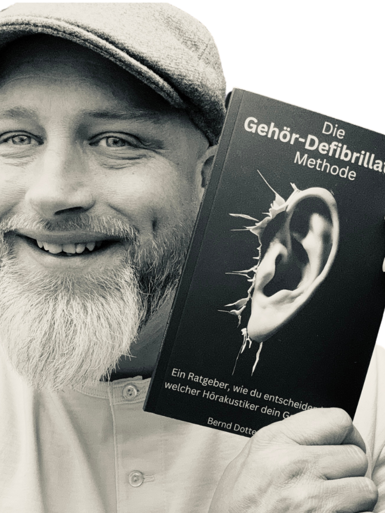 Ein lächelnder Mann hält ein Buch über die Gehör-Orientierungsmethode in der Hand.