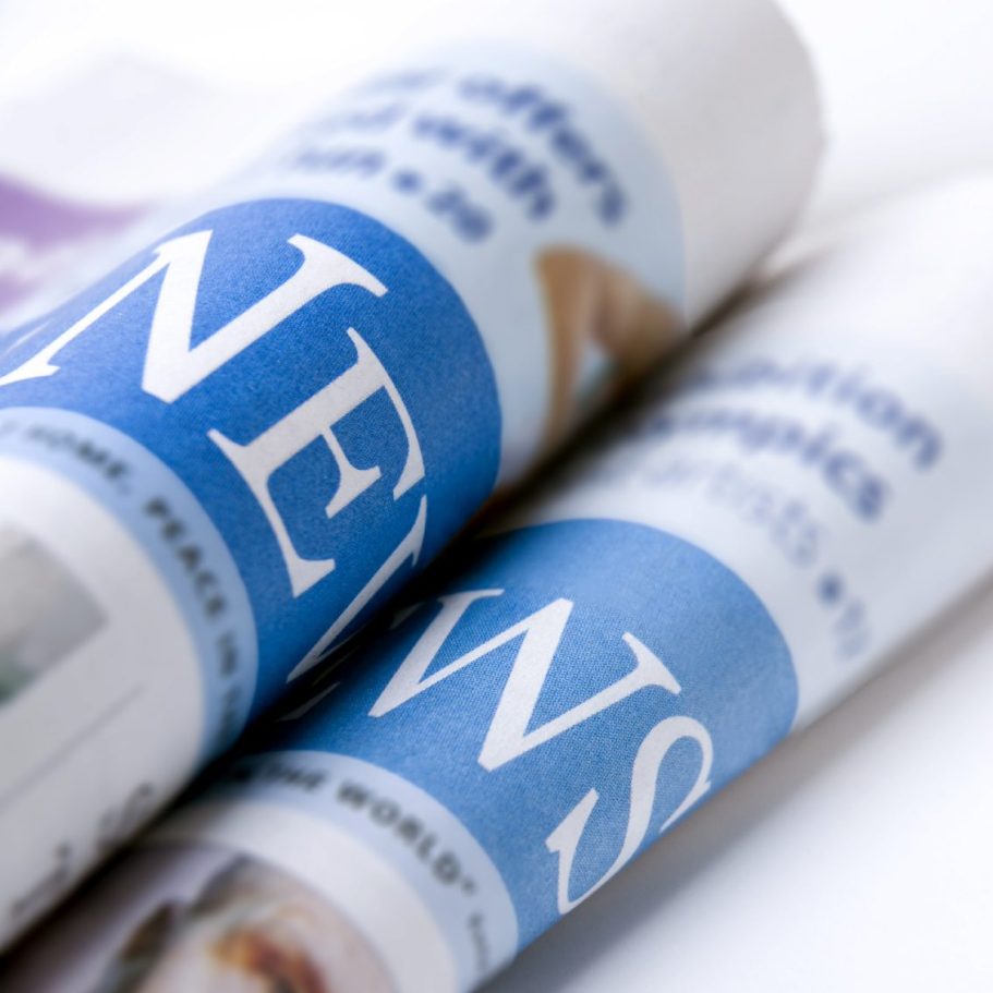 Nahaufnahmen von Zeitungen mit dem Wort "NEWS" deutlich sichtbar.